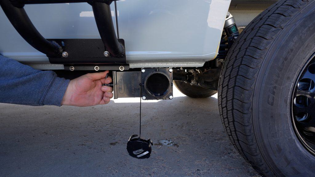 Pictured is your van's grey water tank valve and tee pull handle.
