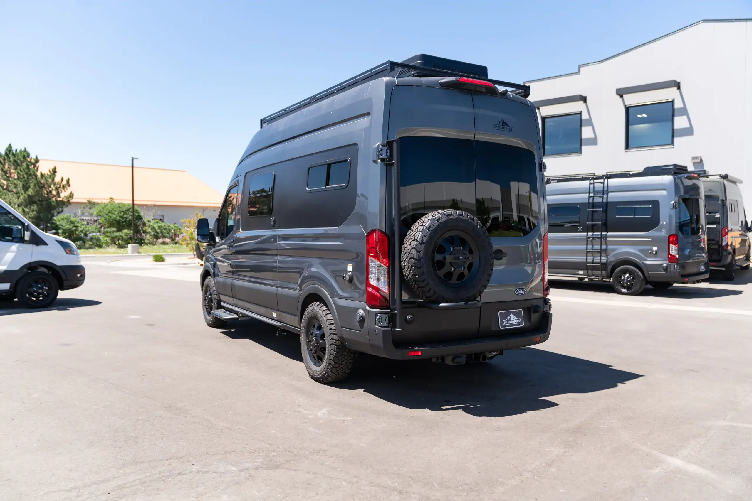 Black 2026 Switchback S4 Transit van parked in lot with other vans.