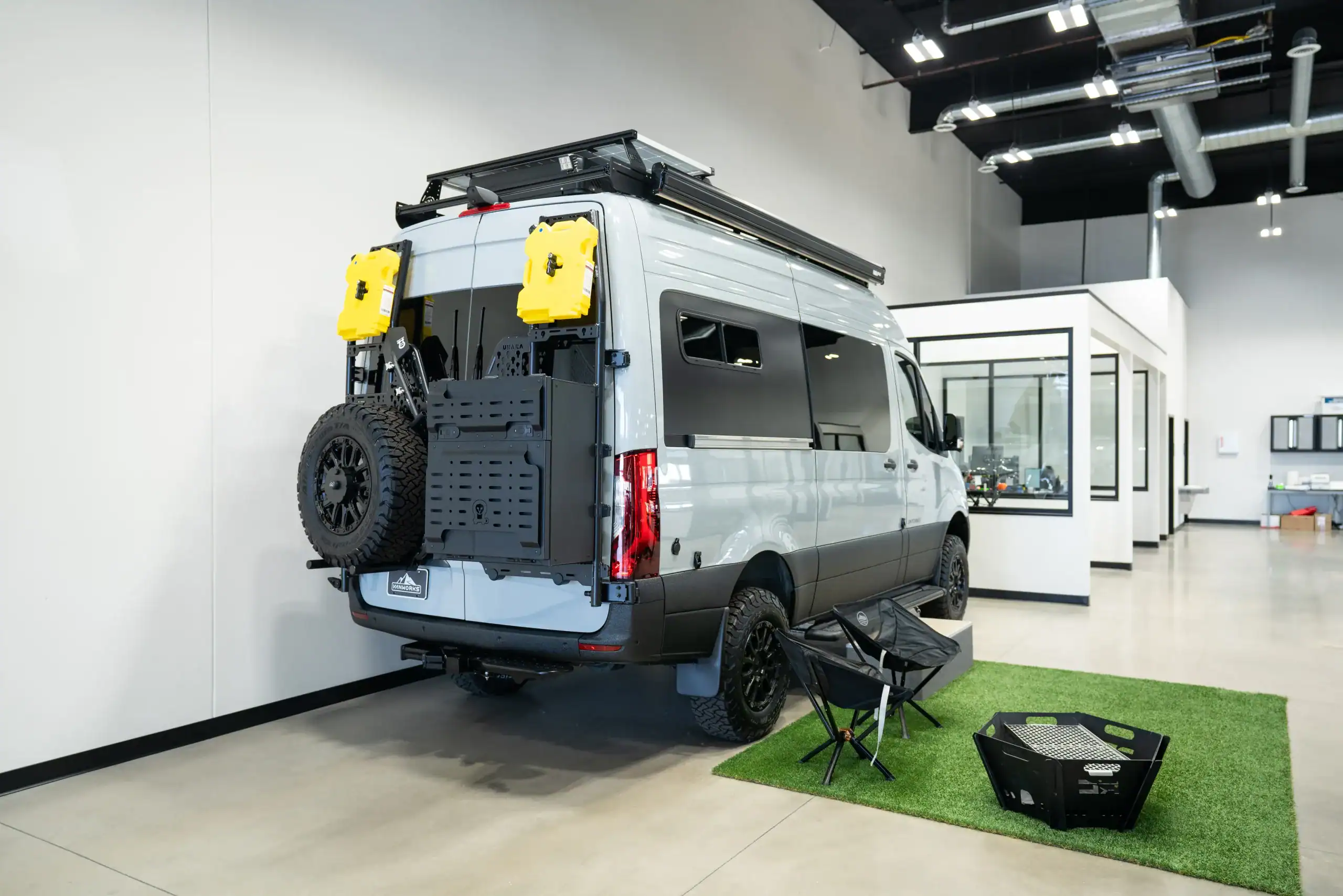 Custom van conversion with roof rack and outdoor gear setup.