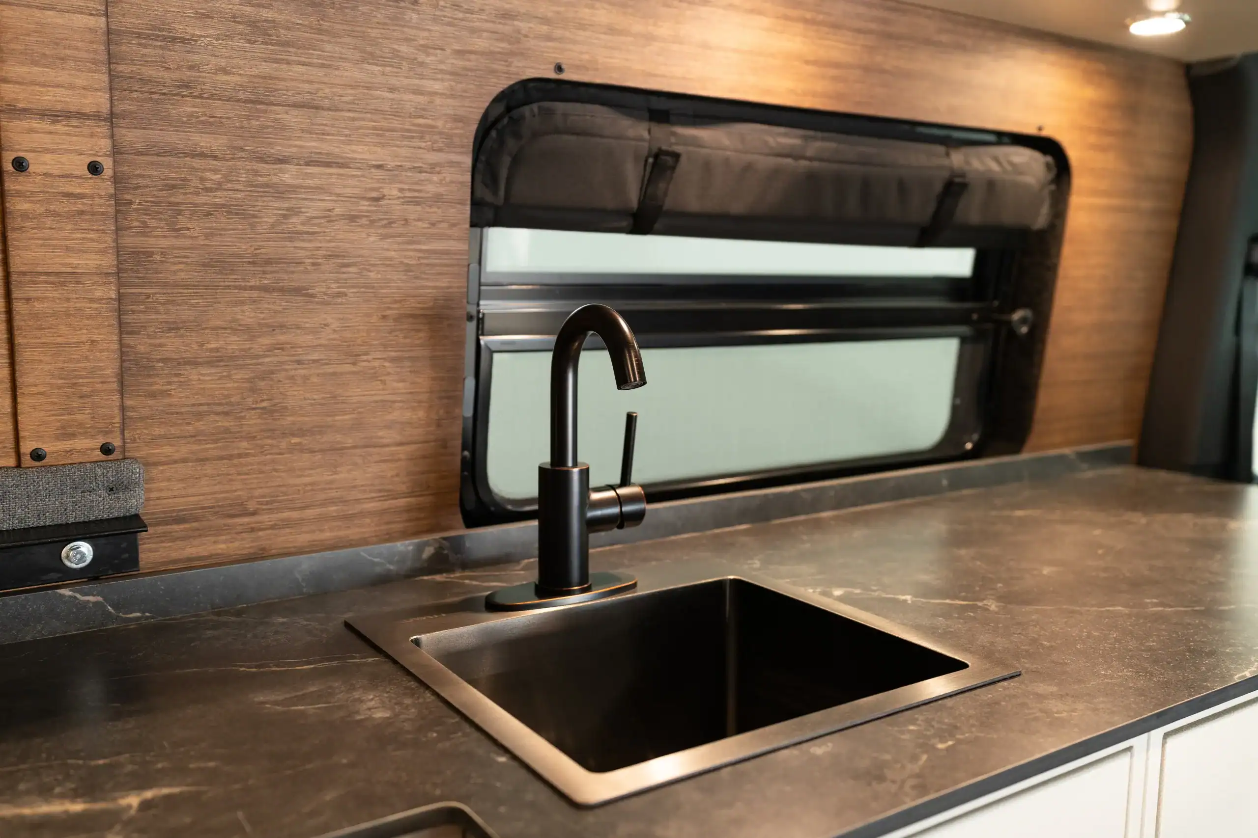 Interior view of kitchen with sink and window in Vanworks Sprinter van.