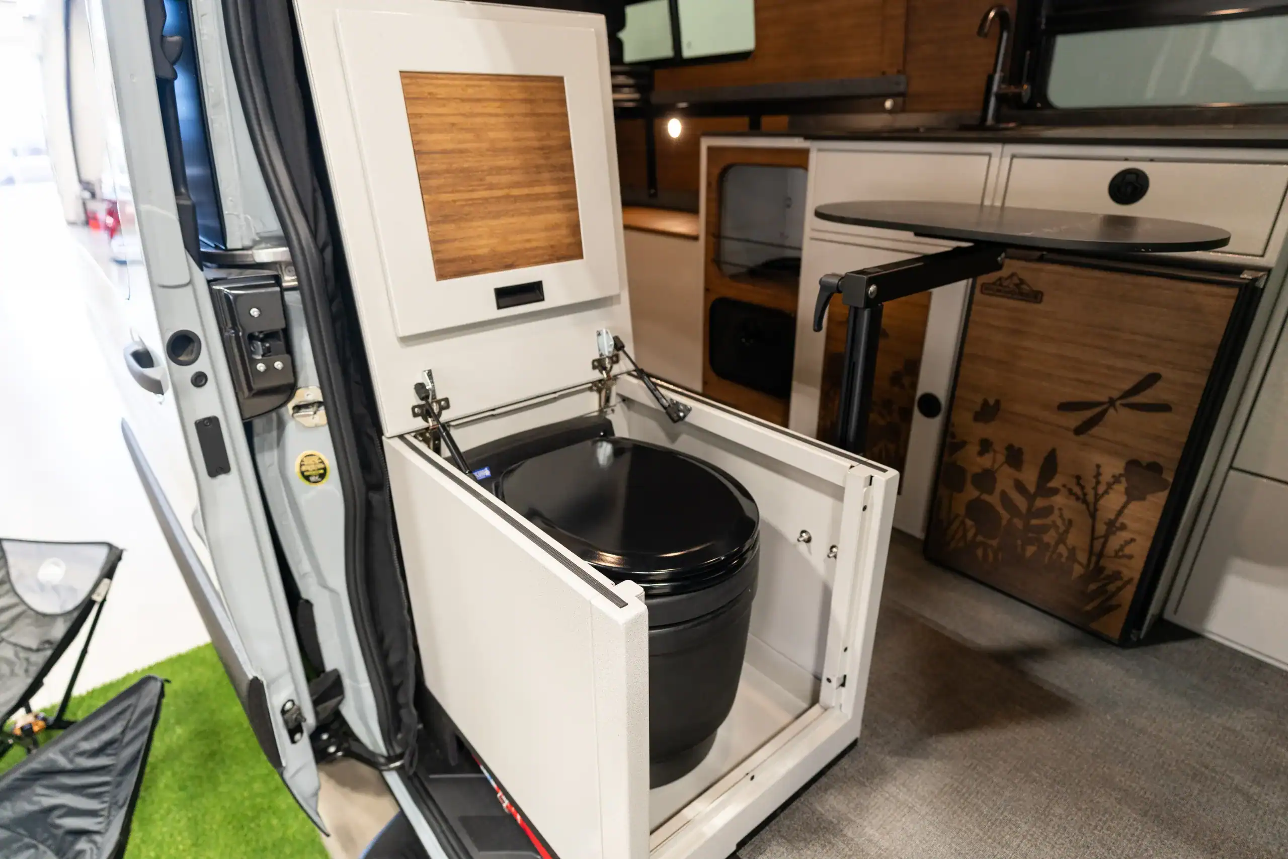 Compact portable toilet setup inside a van for travel and camping.