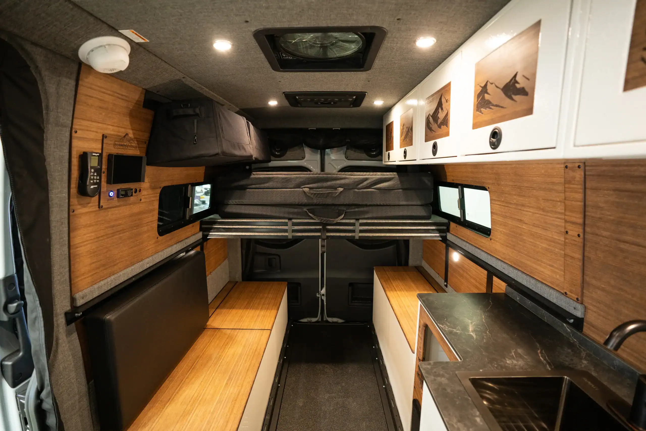 Interior view of the Switchback Sprinter 144 van with wood accents and seating.