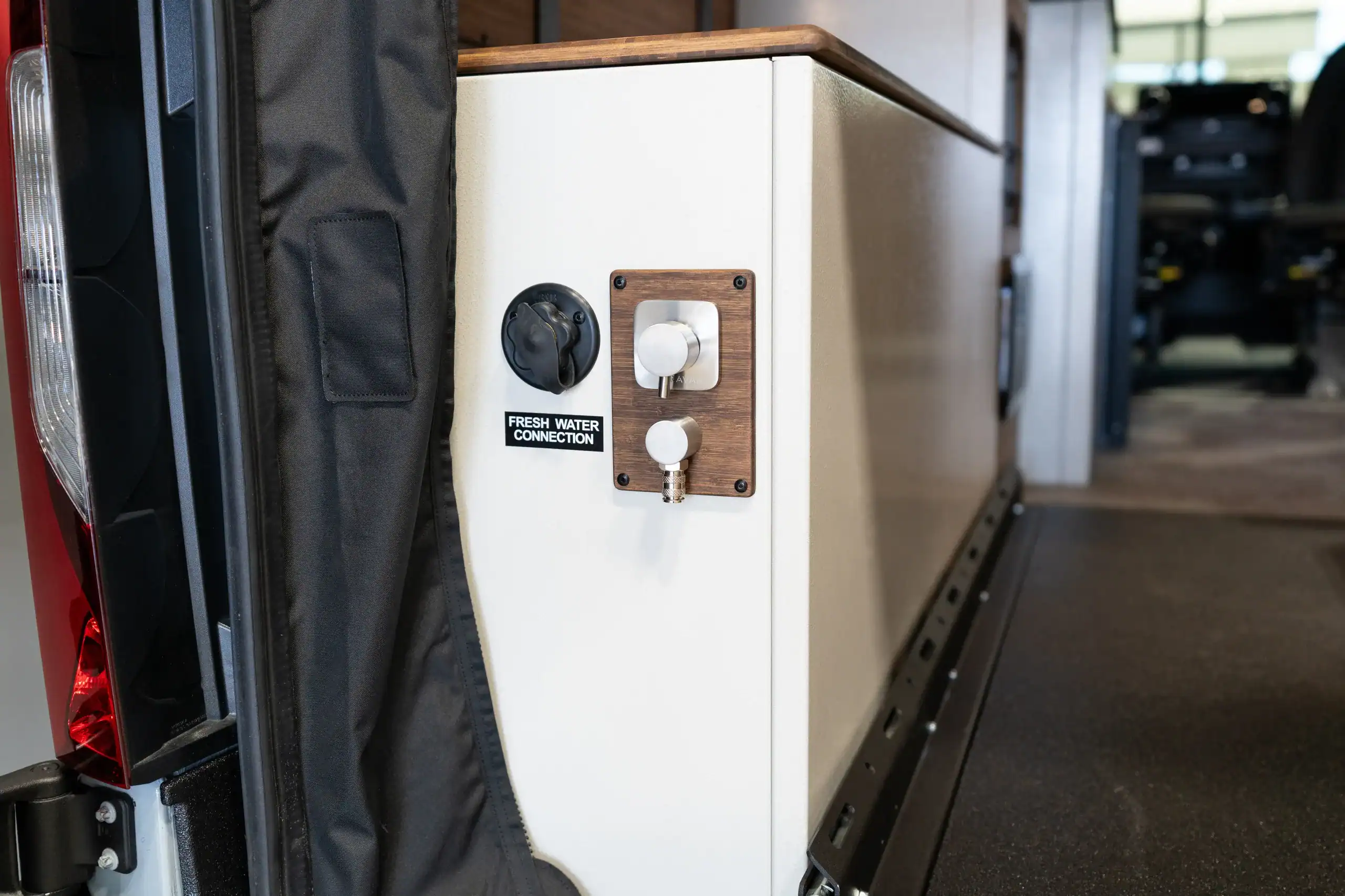 Close-up of water connection panel in Vanworks Switchback Sprinter 144" Show Van.