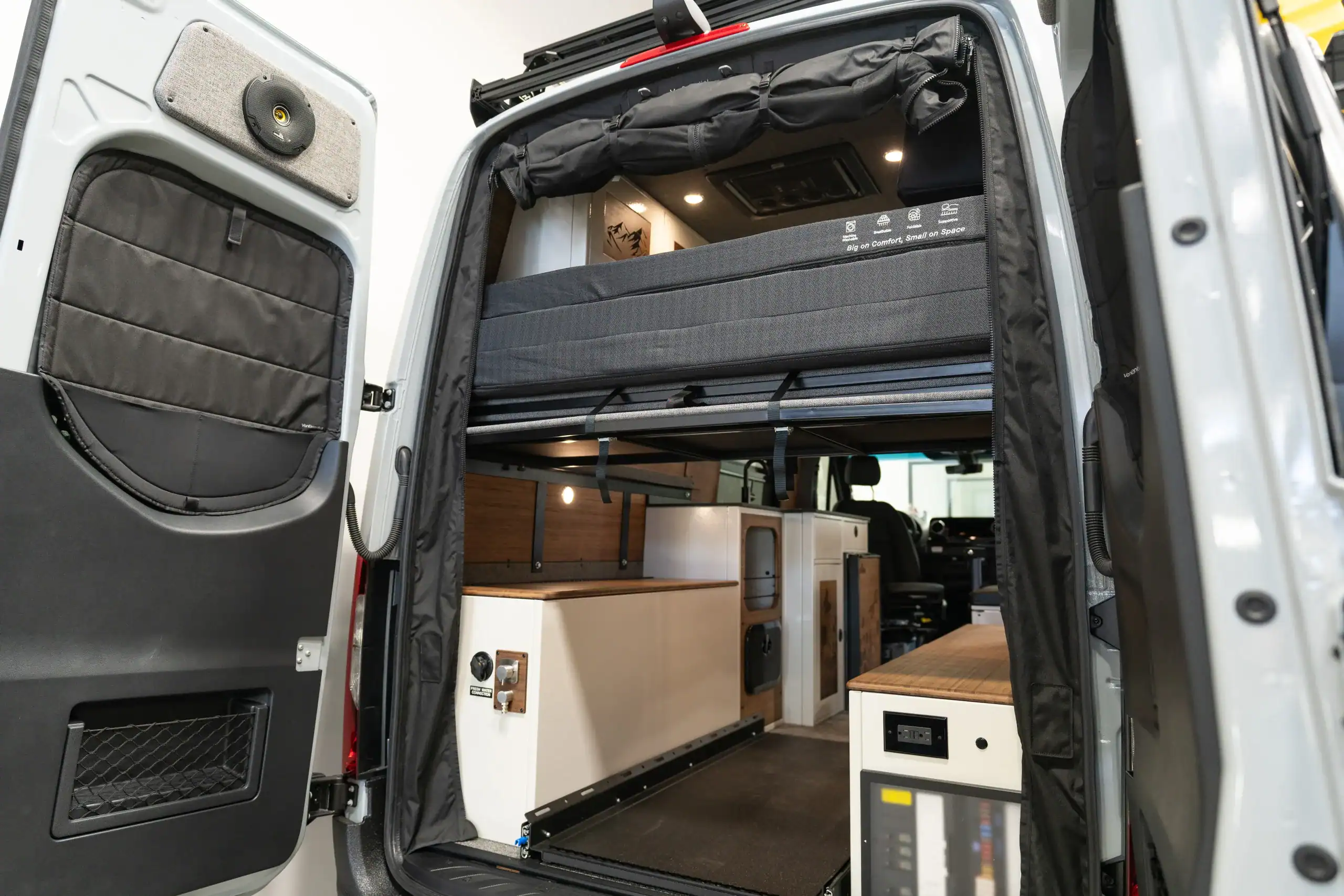 Interior view of the Switchback Sprinter 144 van with custom cabinetry and sleeping area.